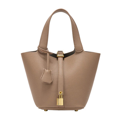 Spacious bucket tote with structured leather body, adjustable shoulder strap, drawstring closure, and minimalist design for everyday carry