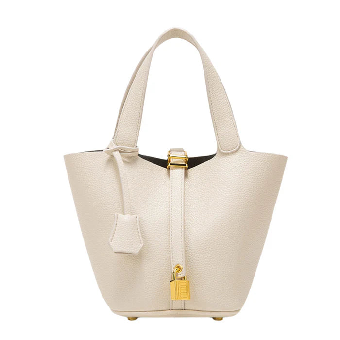 Spacious bucket tote with structured leather body, adjustable shoulder strap, drawstring closure, and minimalist design for everyday carry