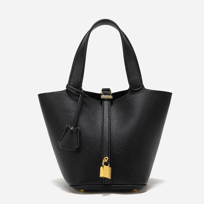 Spacious bucket tote with structured leather body, adjustable shoulder strap, drawstring closure, and minimalist design for everyday carry