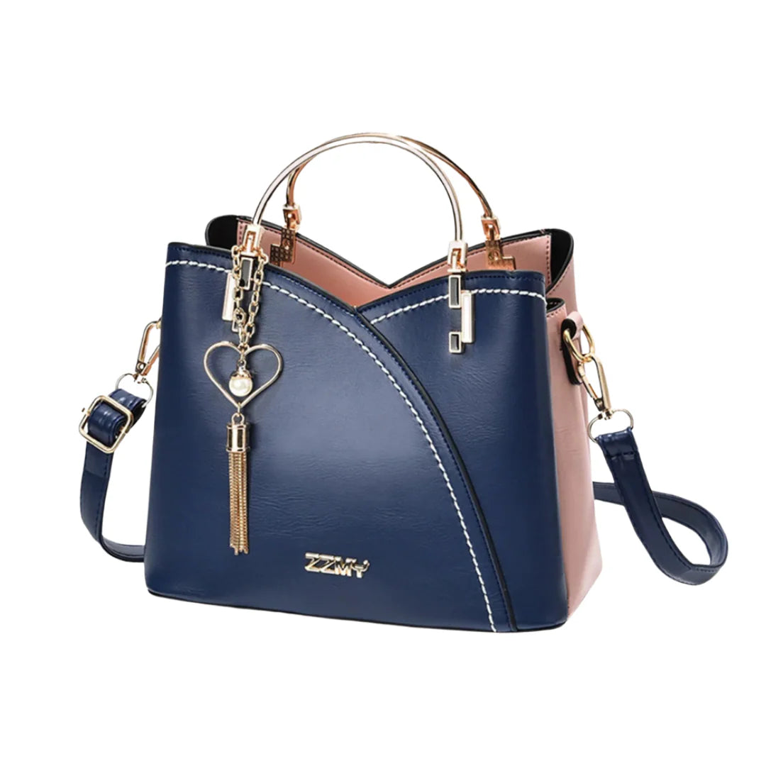 Ivory and taupe two-tone faux leather tote bag with gold-tone hardware, dual top handles, detachable crossbody strap, and heart-shaped charm with pearl accent.