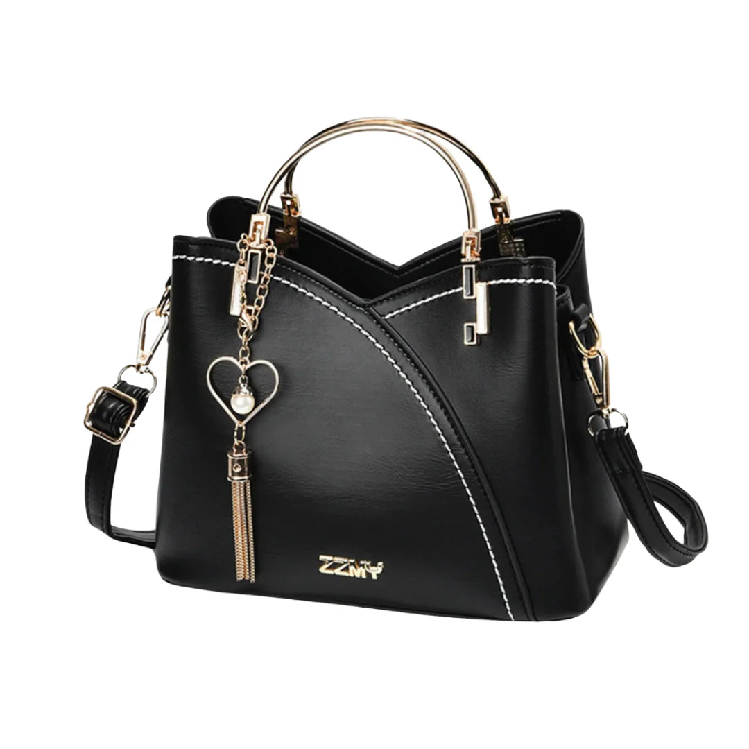 Ivory and taupe two-tone faux leather tote bag with gold-tone hardware, dual top handles, detachable crossbody strap, and heart-shaped charm with pearl accent.