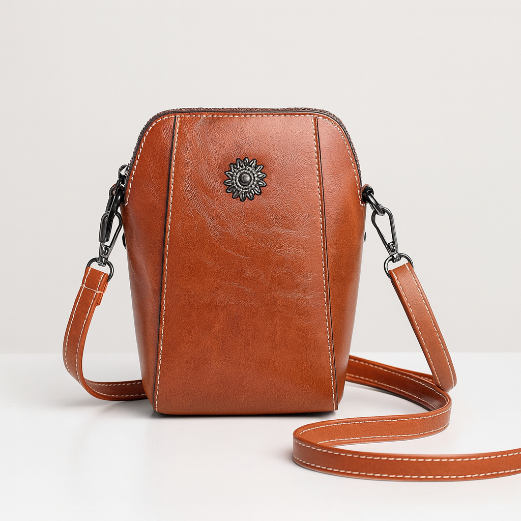 Compact crossbody bag with sleek leather finish, adjustable strap, secure top zip closure, and minimalist design for everyday use