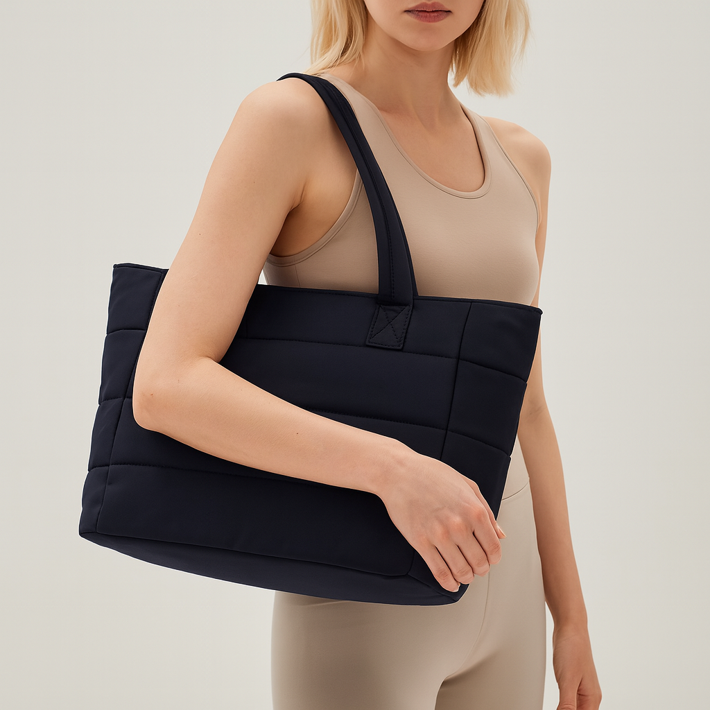 Quilted tote bag with a spacious main compartment, soft padded design, and sturdy shoulder straps for daily use.