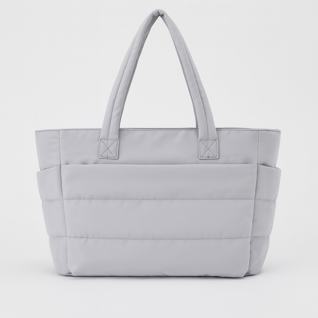Quilted tote bag with a spacious main compartment, soft padded design, and sturdy shoulder straps for daily use.