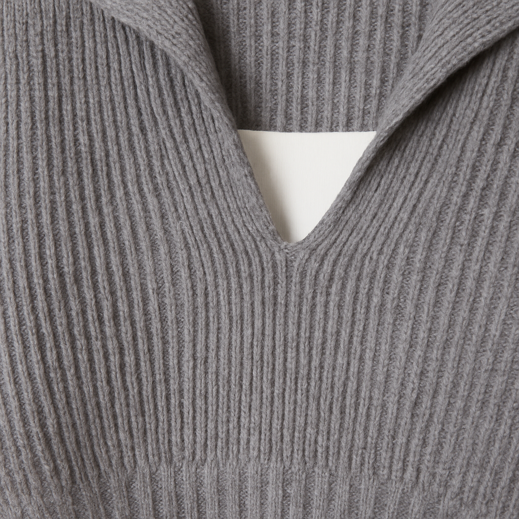 Grey ribbed knit cropped sweater with V-neck and collar detail.