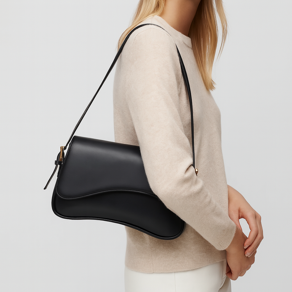 Curved flap shoulder bag with smooth leather finish, adjustable strap, magnetic closure, and sleek minimalist design for everyday wear
